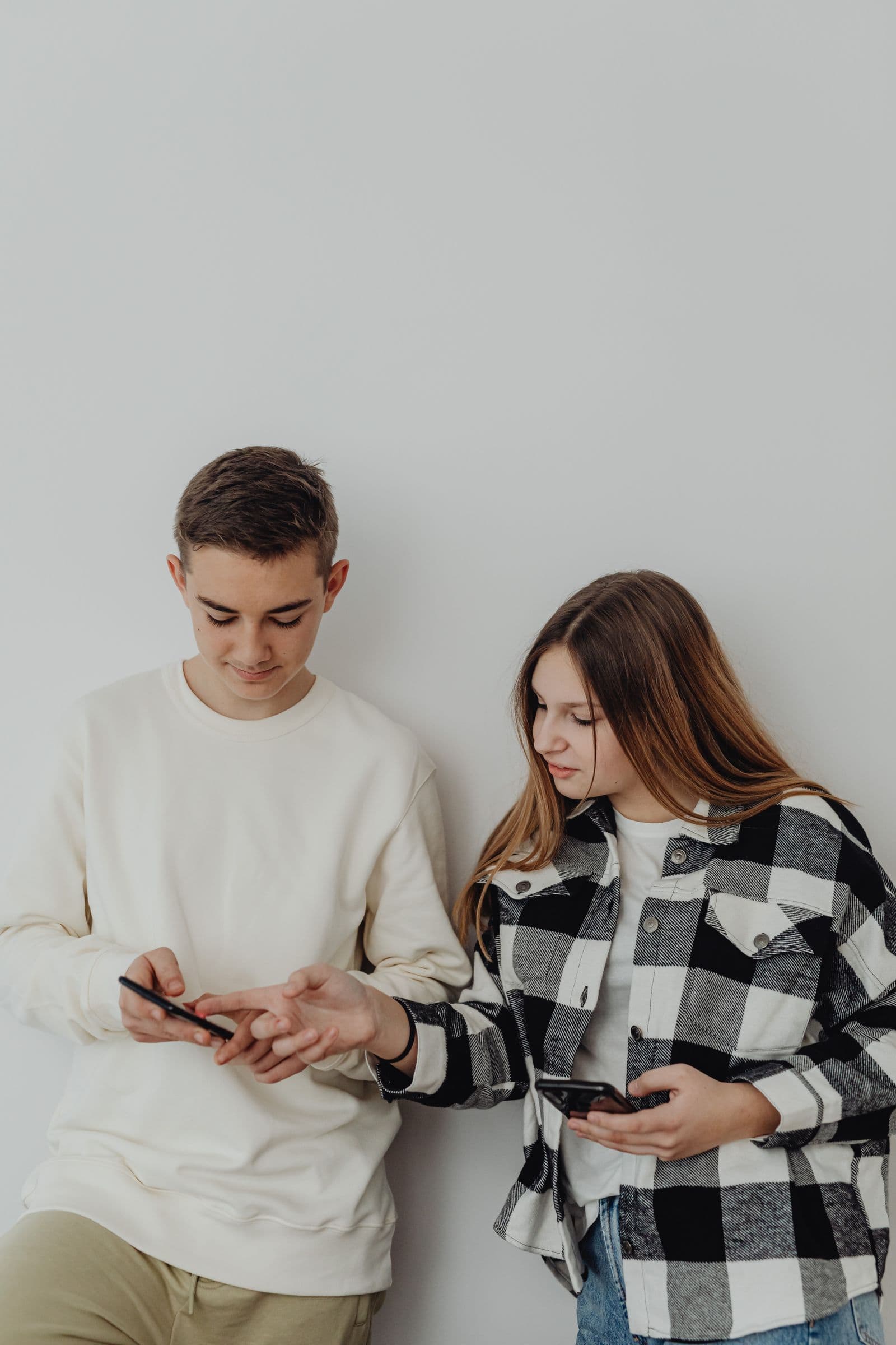 Two young people reviewing a form together on a phone