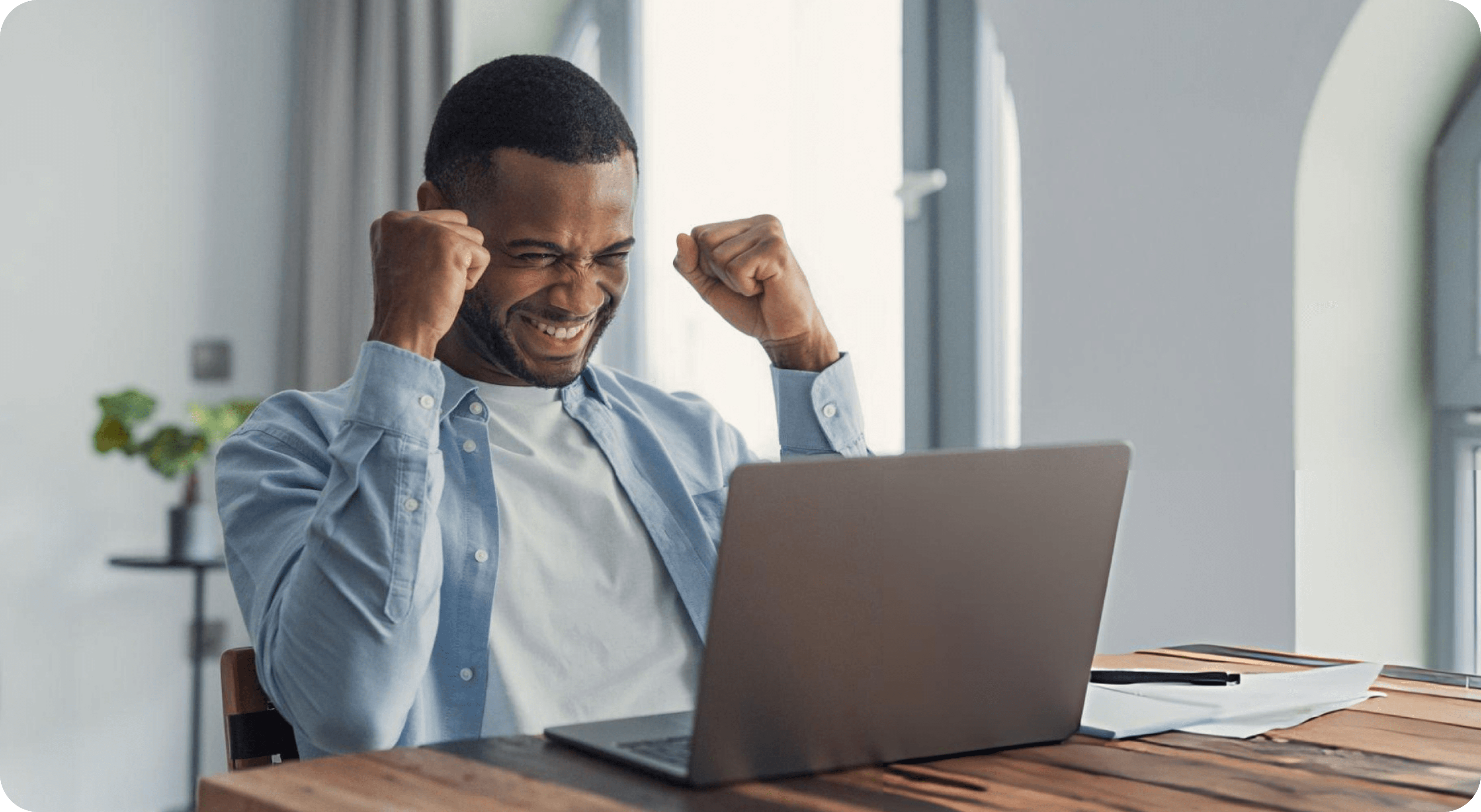 A creator celebrating a winning offer at their laptop